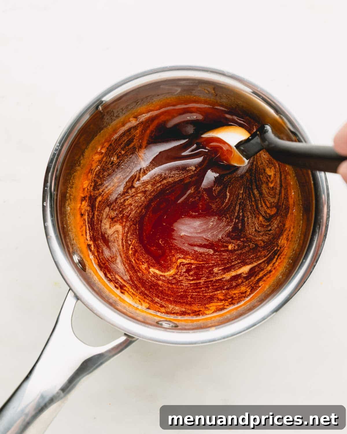 Golden Blaze Drizzle 6 Hot honey sauce being stirred gently in a pot, showing its smooth consistency.