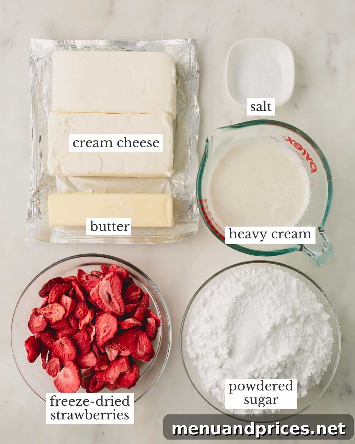 Strawberry Cheesecake Frosting 3 All the key ingredients for strawberry cream cheese frosting laid out: softened cream cheese, room-temperature butter, freeze-dried strawberries, powdered sugar, cold heavy cream, and a pinch of salt.