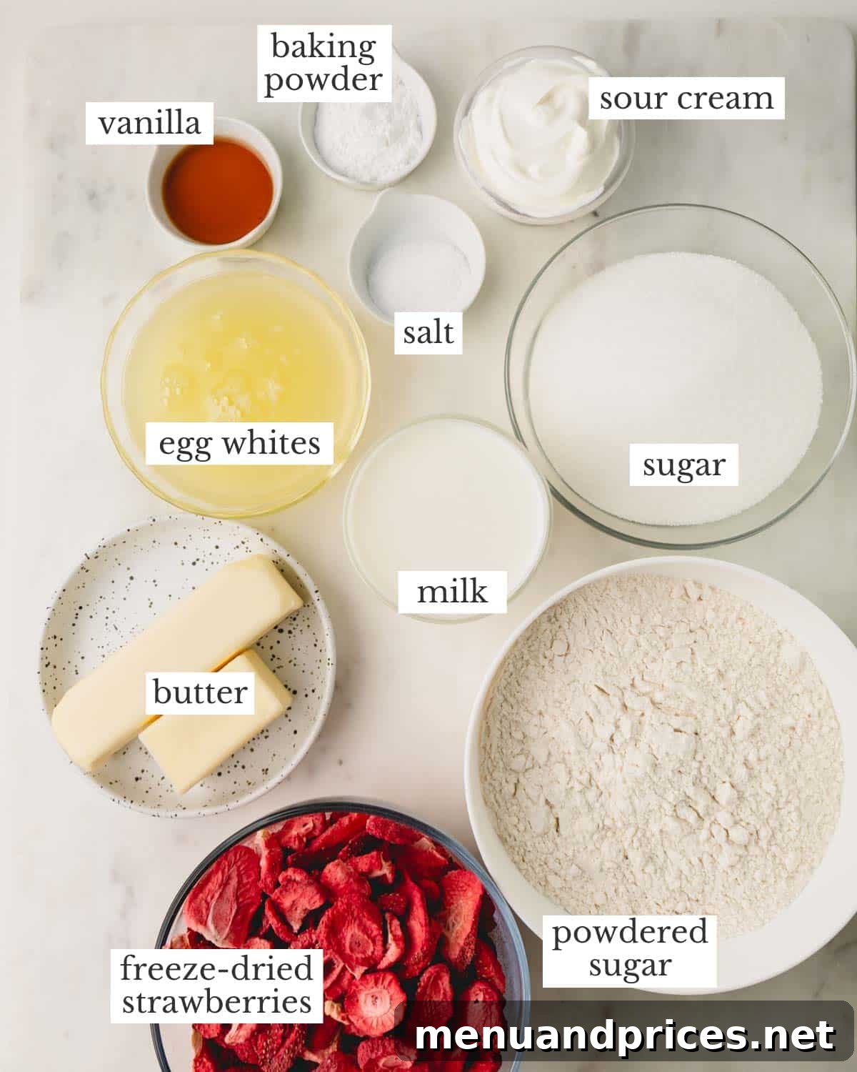 Sweet Strawberry Dream 4 A collection of fresh ingredients meticulously arranged for making homemade strawberry cake, including bags of freeze-dried strawberries, measuring cups, eggs, butter, and bottles of milk and vanilla extract.
