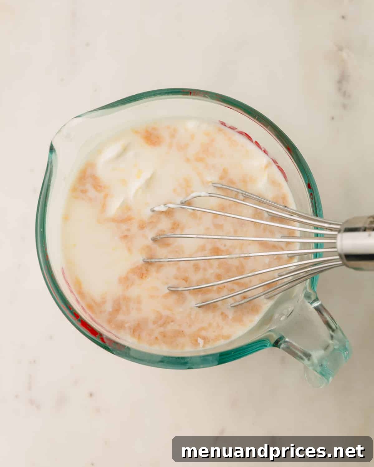 Sweet Strawberry Dream 7 Wet ingredients for the strawberry cake batter, including milk, sour cream, and vanilla, being whisked together in a clear liquid measuring cup.