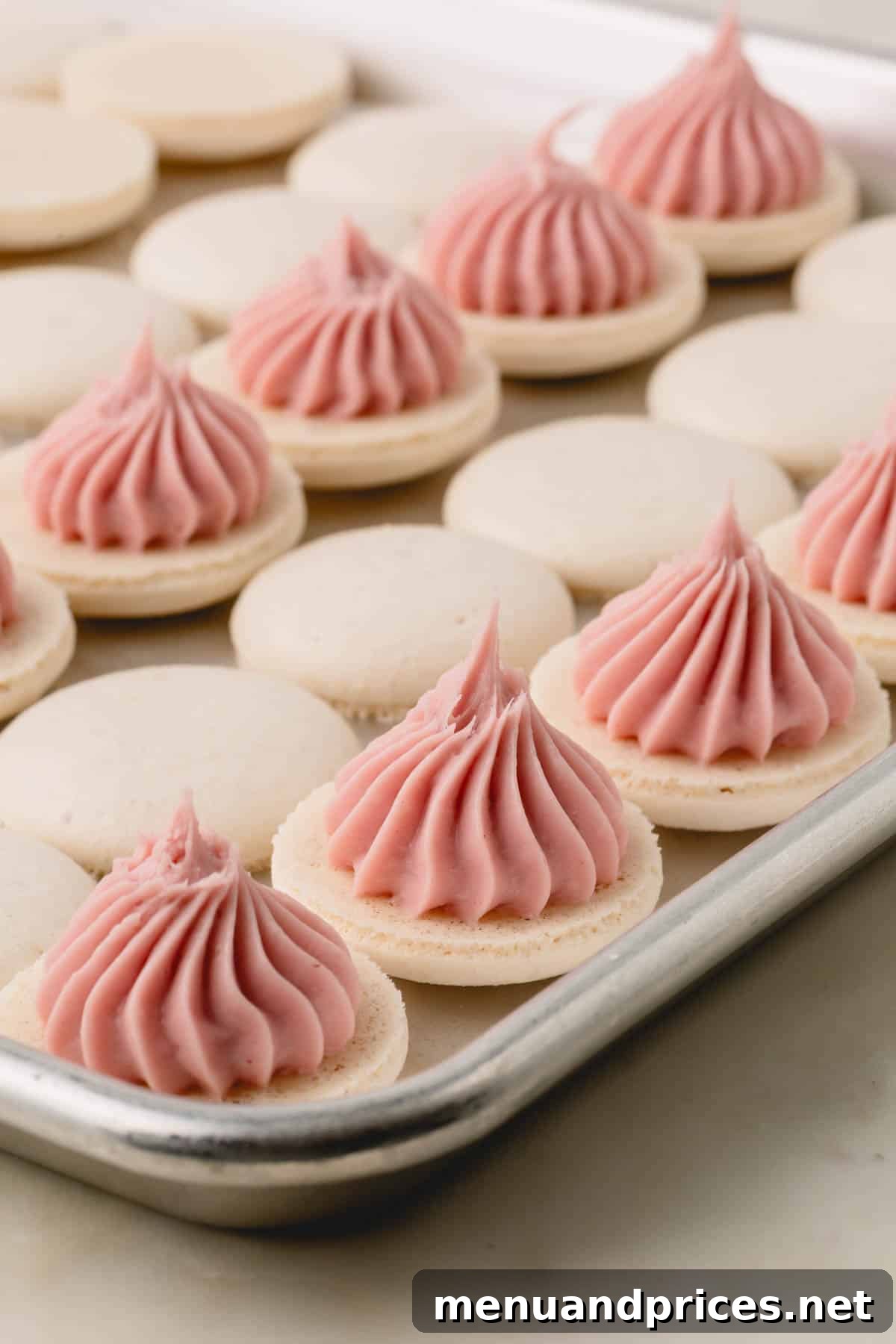 Strawberry Silk Dairy Free Ganache 2 White macaron shells elegantly topped with luscious dairy-free strawberry ganache, showcasing its beautiful texture.