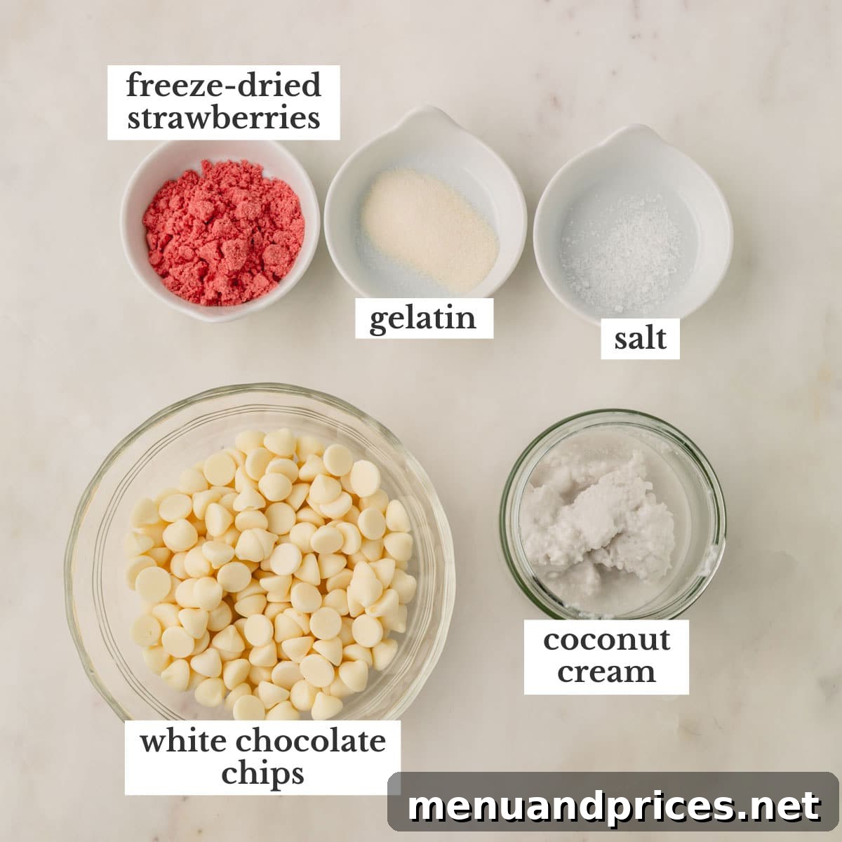 Strawberry Silk Dairy Free Ganache 3 Individual ingredients for dairy-free strawberry ganache: freeze-dried strawberries, gelatin, salt, coconut cream, and white chocolate chips arranged on a surface.