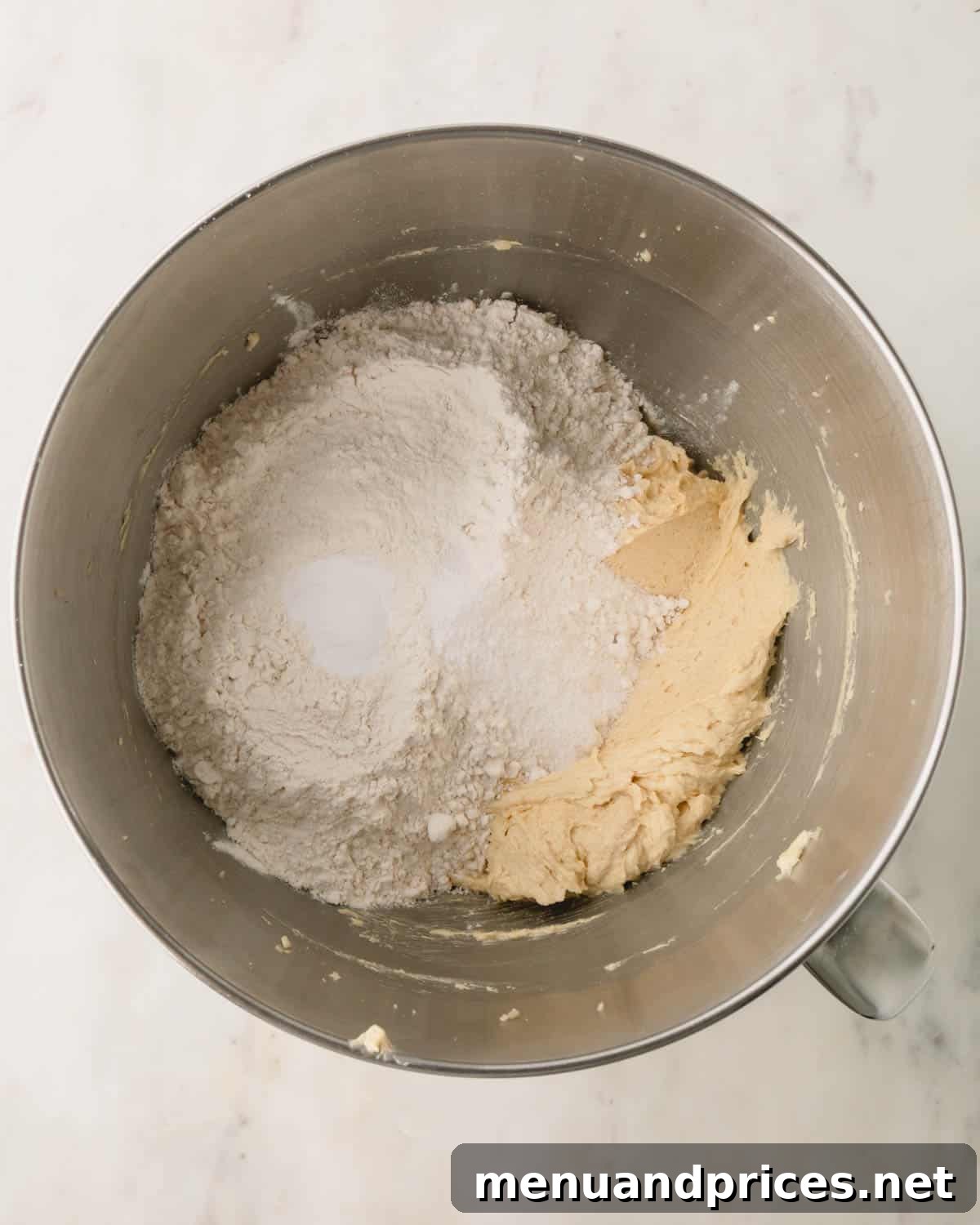 Decadent Thick and Chewy Chocolate Chip Cookies 10 Dry ingredients being gently added to the wet cookie dough mixture.