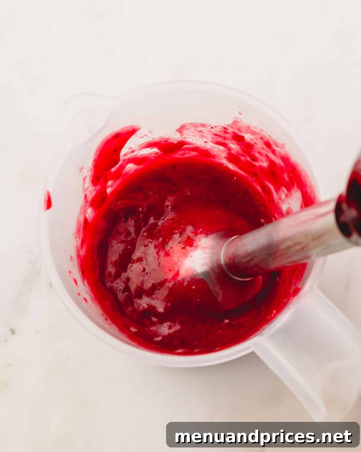 Fresh cranberries, sugar, water, and orange zest simmering gently in a saucepan.