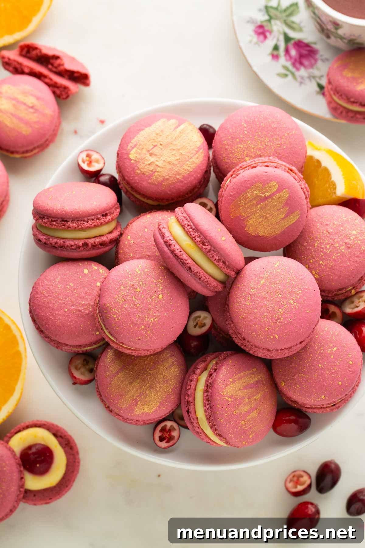 A cake stand topped with golden-dusted orange cranberry macarons, exuding elegance.
