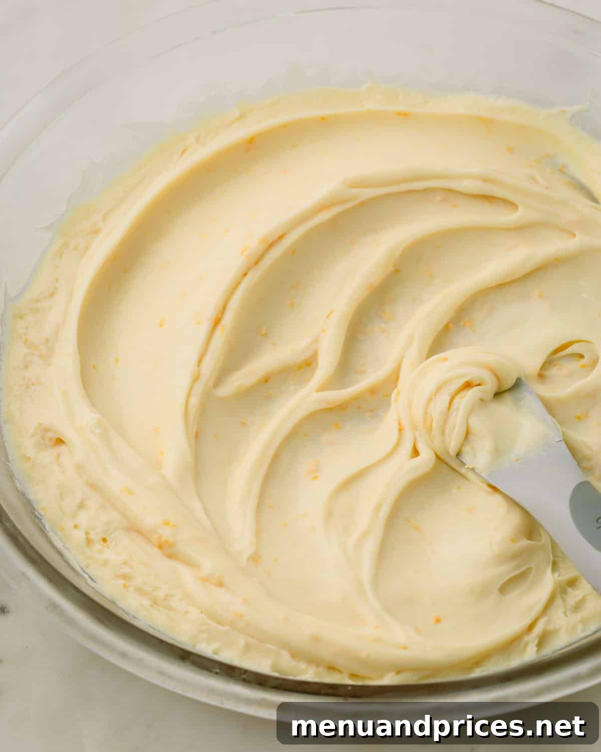A bowl of smooth, glossy white chocolate orange ganache after chilling and stirring.