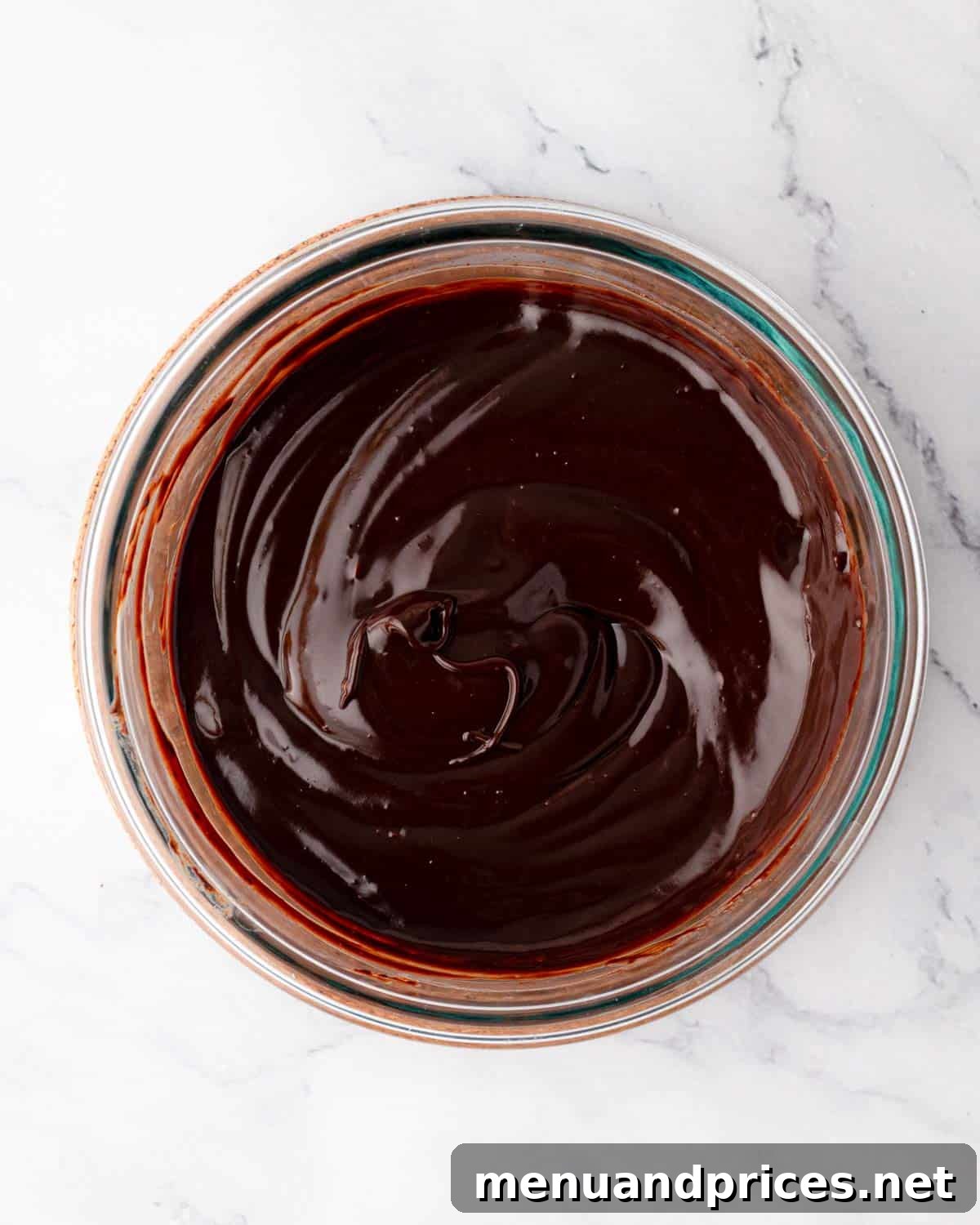 Smooth and glossy chocolate ganache in a bowl after being stirred.