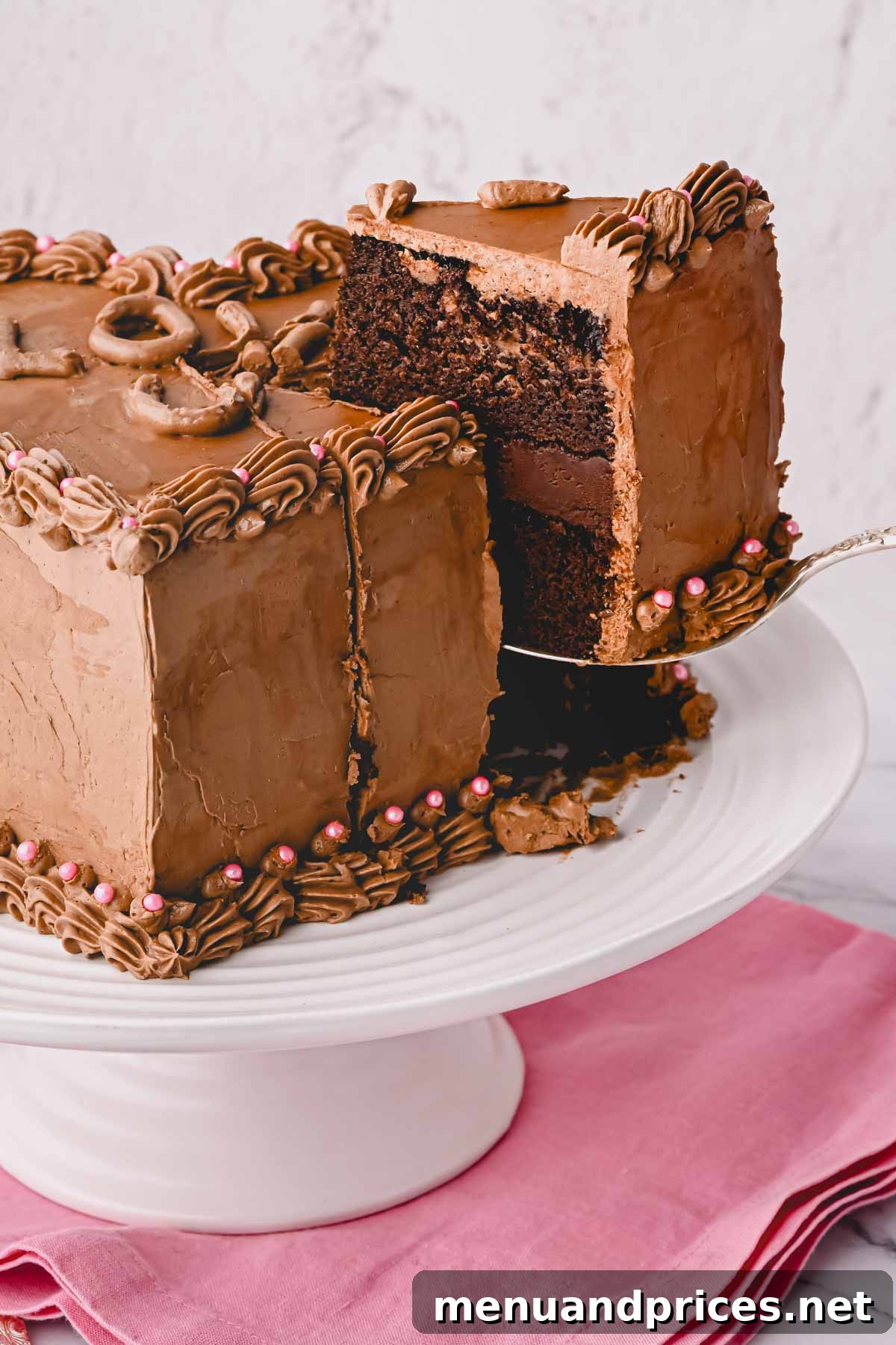 A perfectly baked chocolate heart cake layer being carefully lifted from a cake pan, showcasing its rich brown hue.