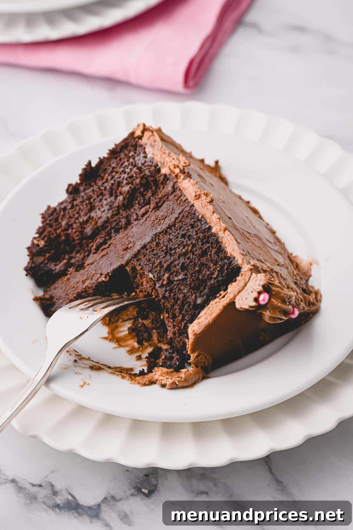 A slice of chocolate heart cake with a fork, showing delicious bites missing, indicating its irresistible nature.