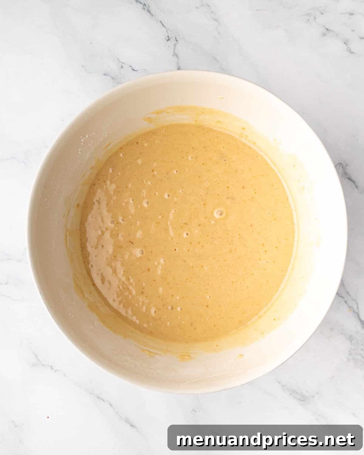 A bowl showing the combined wet and dry ingredients for the chocolate cake batter.