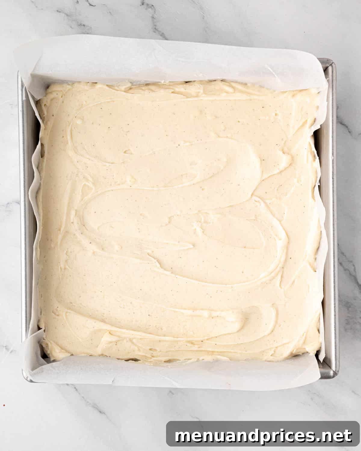 Crimson Velvet Brownies 17 A square baking pan of red velvet brownies, now beautifully topped with a smooth layer of cream cheese frosting.