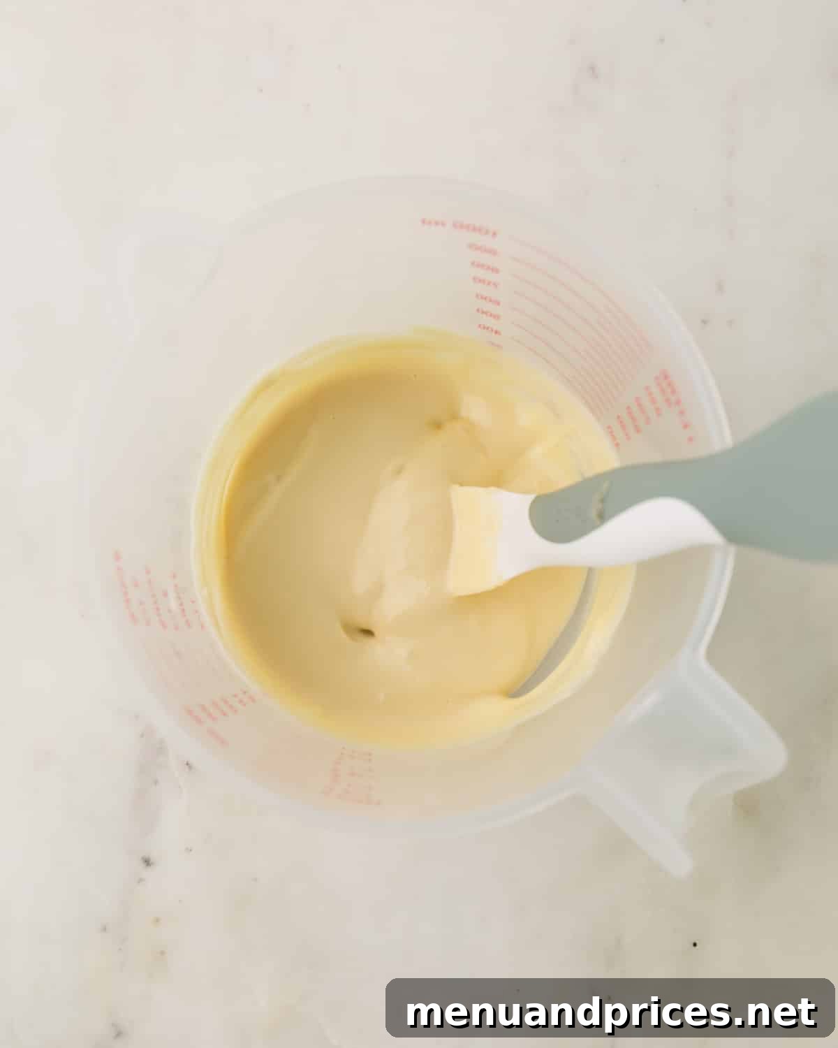 Espresso Dream Macarons 15 Melted white chocolate in a plastic measuring cup.