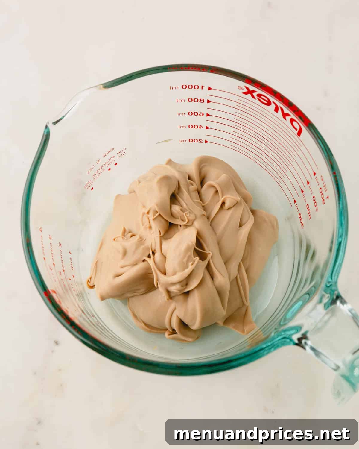 Espresso Dream Macarons 22 Espresso ganache is transferred into a big measuring cup.