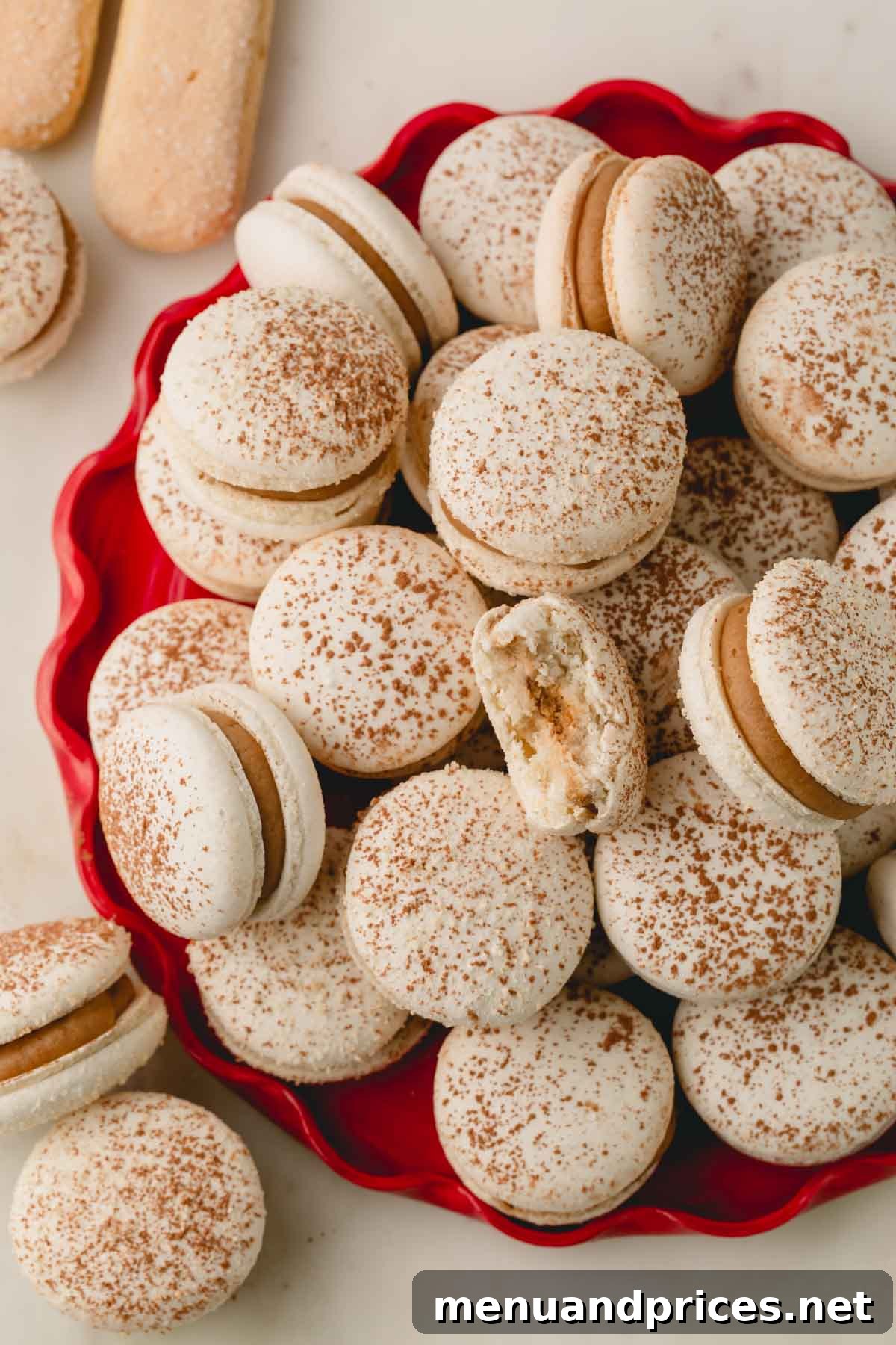 Espresso Dream Macarons 29 Upclose shot of tiramisu macarons on a red circle plate with one macaron bitten.