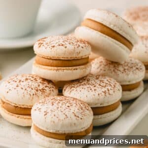 Tiramisu macarons stacked on a long white serving plate.