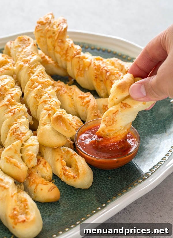A platter filled with warm, freshly baked homemade roasted garlic and cheese breadsticks, garnished slightly, ready to be served and enjoyed.