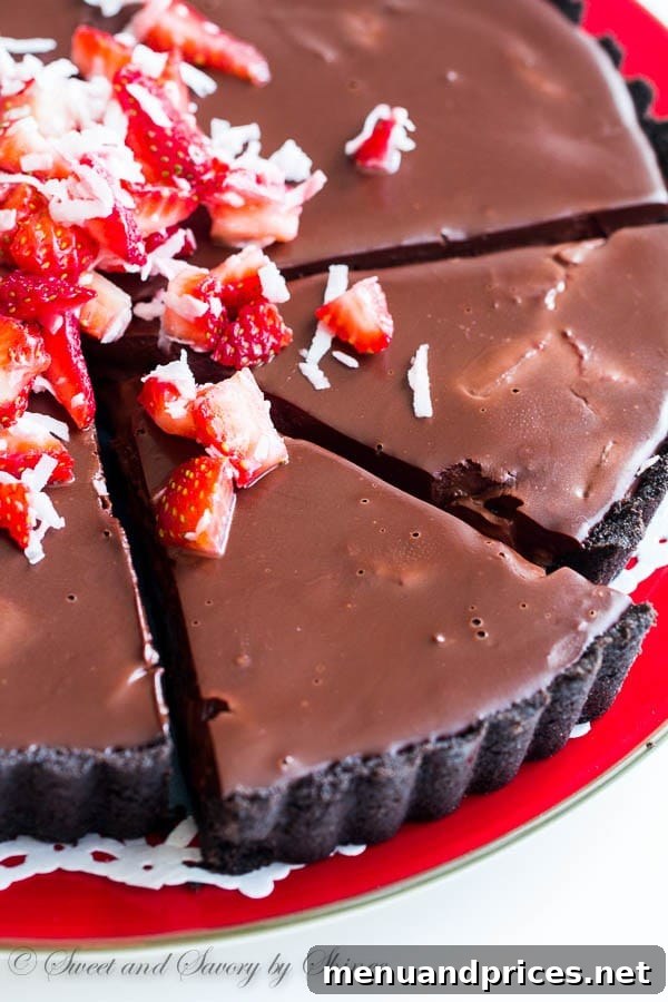 Decadent Chocolate Dream Tart 2 Rich no-bake chocolate truffle tart with fresh strawberries and coconut flakes on top, perfect for spring.