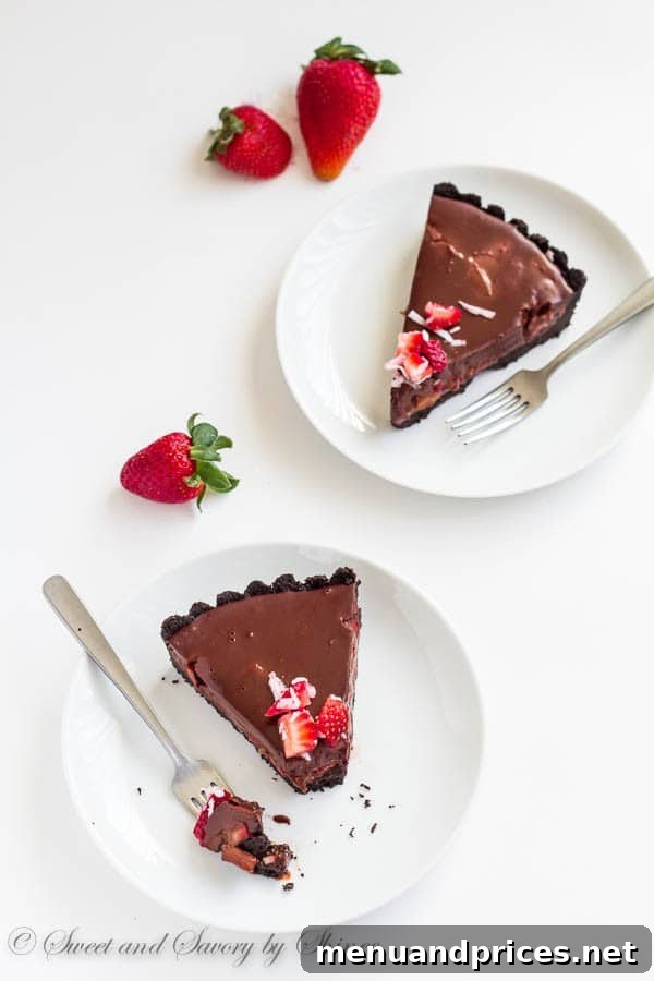 Decadent Chocolate Dream Tart 4 A whole no-bake chocolate truffle tart with berries and coconut, ready to be sliced.