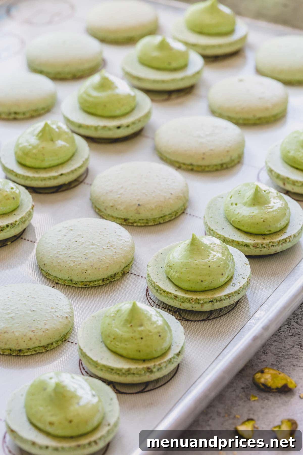 Heavenly Pistachio Macarons 12 Open pistachio macaron shells with a dollop of creamy pistachio filling, ready to be assembled.