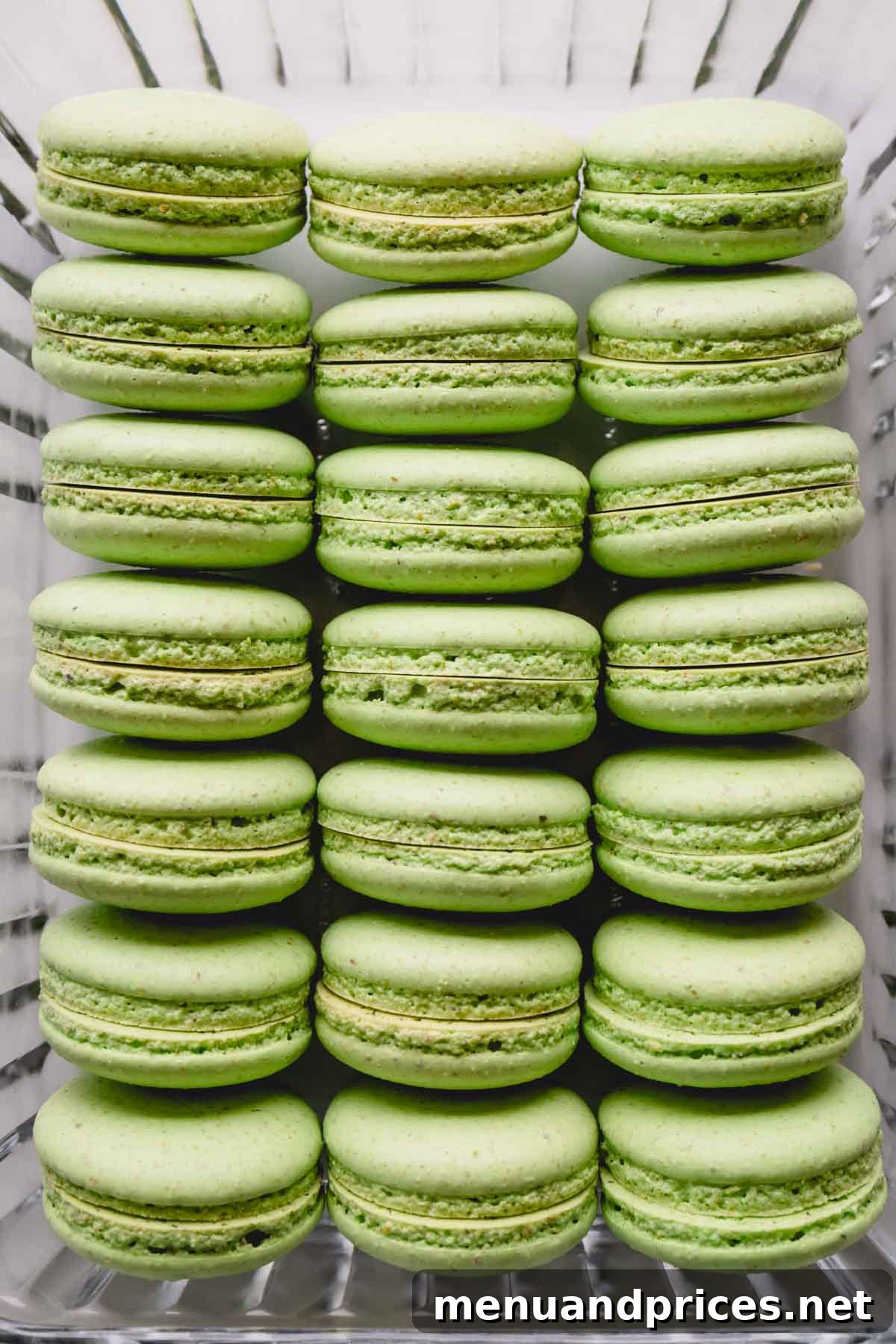 Heavenly Pistachio Macarons 4 Perfectly paired pistachio macaron shells, ready for their delicious filling, nestled in a glass container.