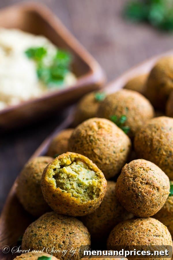 Craft Your Own Falafel 7 Homemade falafel balls beautifully arranged with a side of hummus and fresh garnishes.