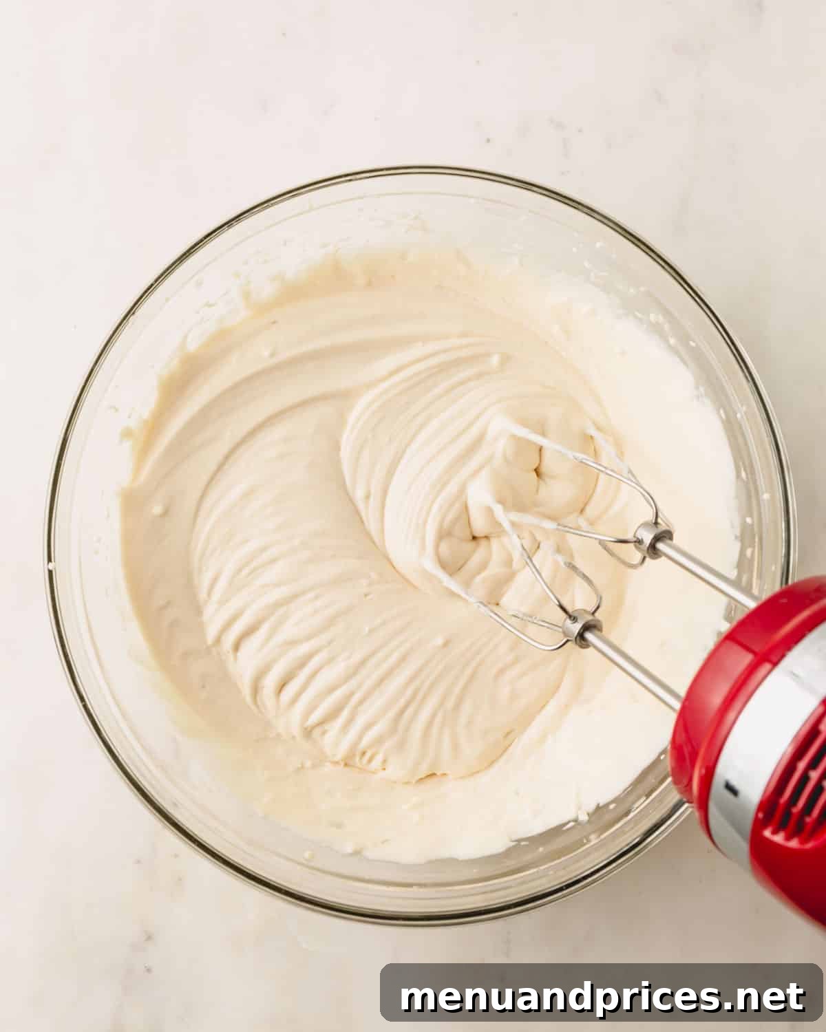 Almond Coconut Delights 6 A bowl of whipped heavy cream with a hand mixer sticking out.