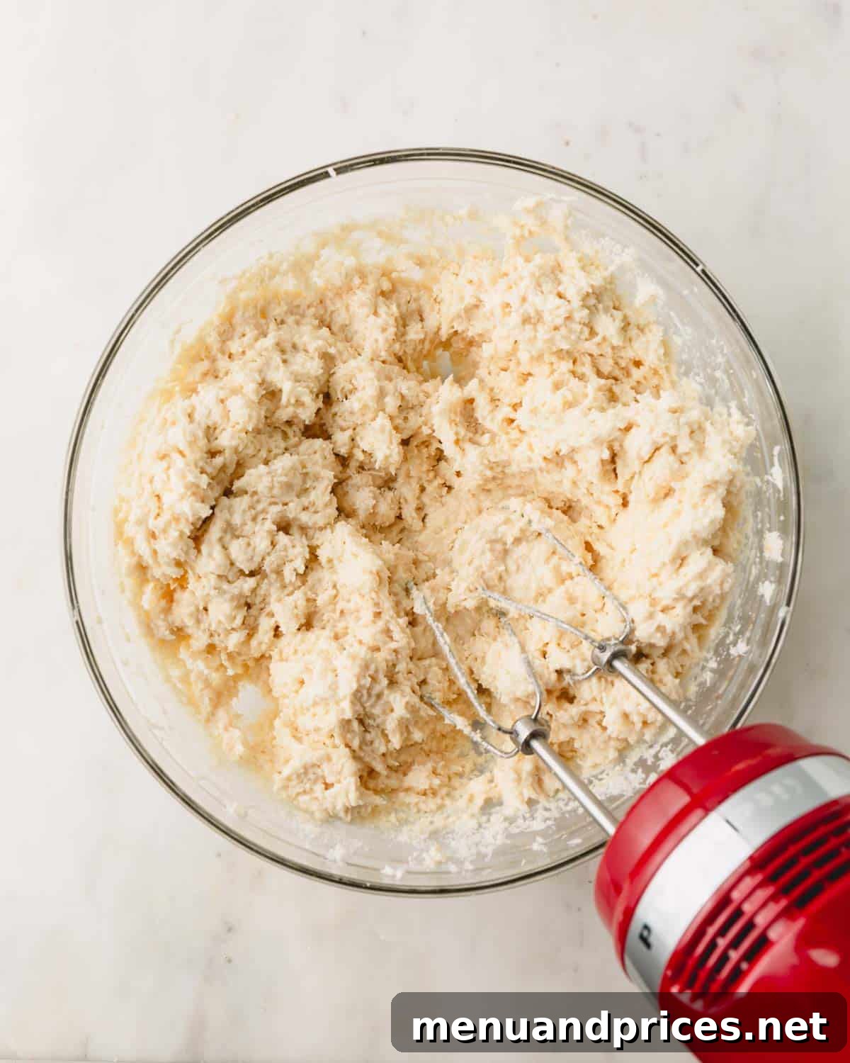 Almond Coconut Delights 8 Coconut ball dough in a bowl with a hand mixer sticking out.
