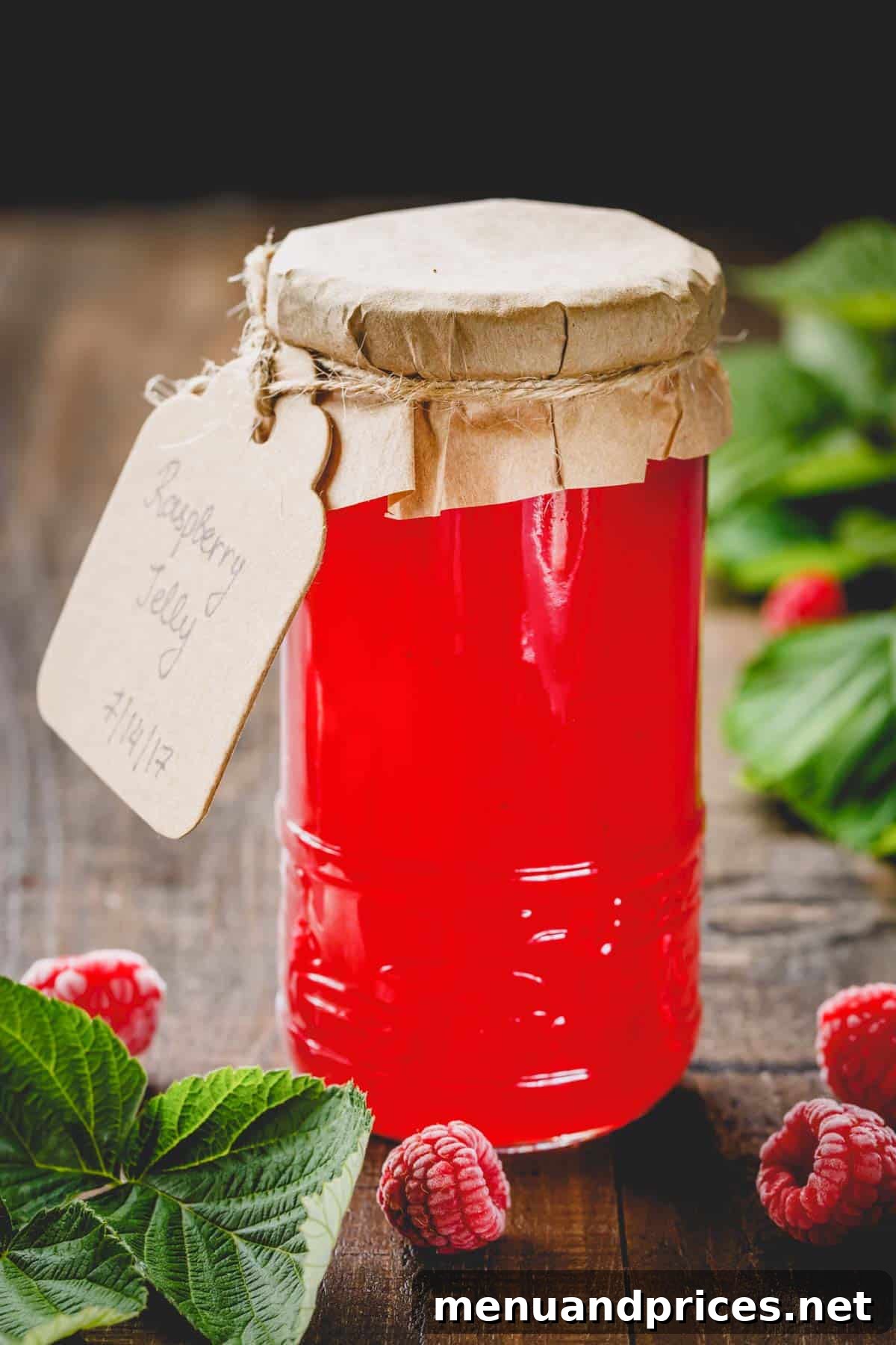 Quick Pectin-Free Raspberry Delight 6 A tall glass jar filled with luscious, seedless raspberry jam, ready for enjoyment.