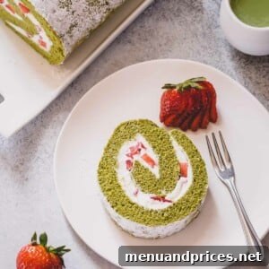 A slice of strawberry matcha roll cake on a white serving plate.