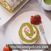 A slice of strawberry matcha roll cake on a white serving plate.