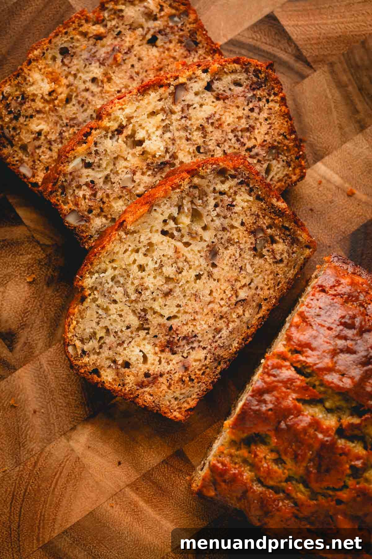 Perfectly golden-brown slices of homemade banana bread, featuring a moist texture and hints of pecans, arranged on a rustic wooden cutting board.