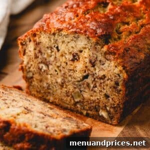 Slices of banana bread and the rest of the loaf on a wooden cutting board.