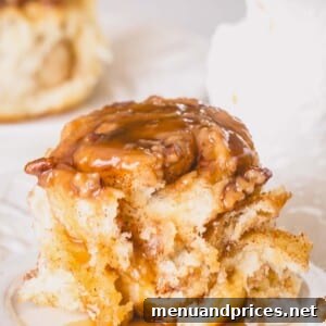 An overnight caramel roll topped with caramel sauce on a plate.