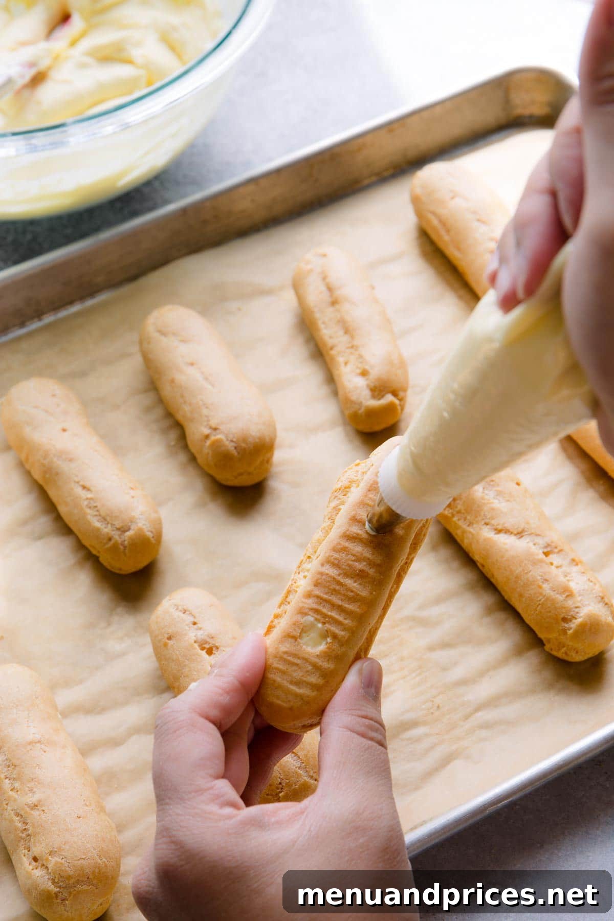 Divine Chocolate Eclairs 11 Filling eclair shell from the bottom using piping holes.