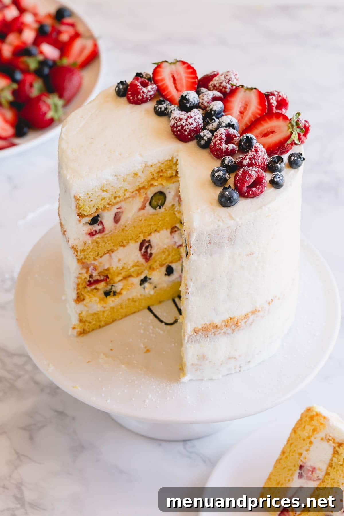 Fresh Berry Chantilly Delight 2 A tall 4-layer Berry Chantilly cake topped with colorful fresh berries on an elegant cake platter, ready to be served.