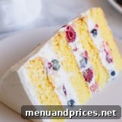 A vibrant Berry Chantilly Cake, garnished with an abundance of fresh berries.