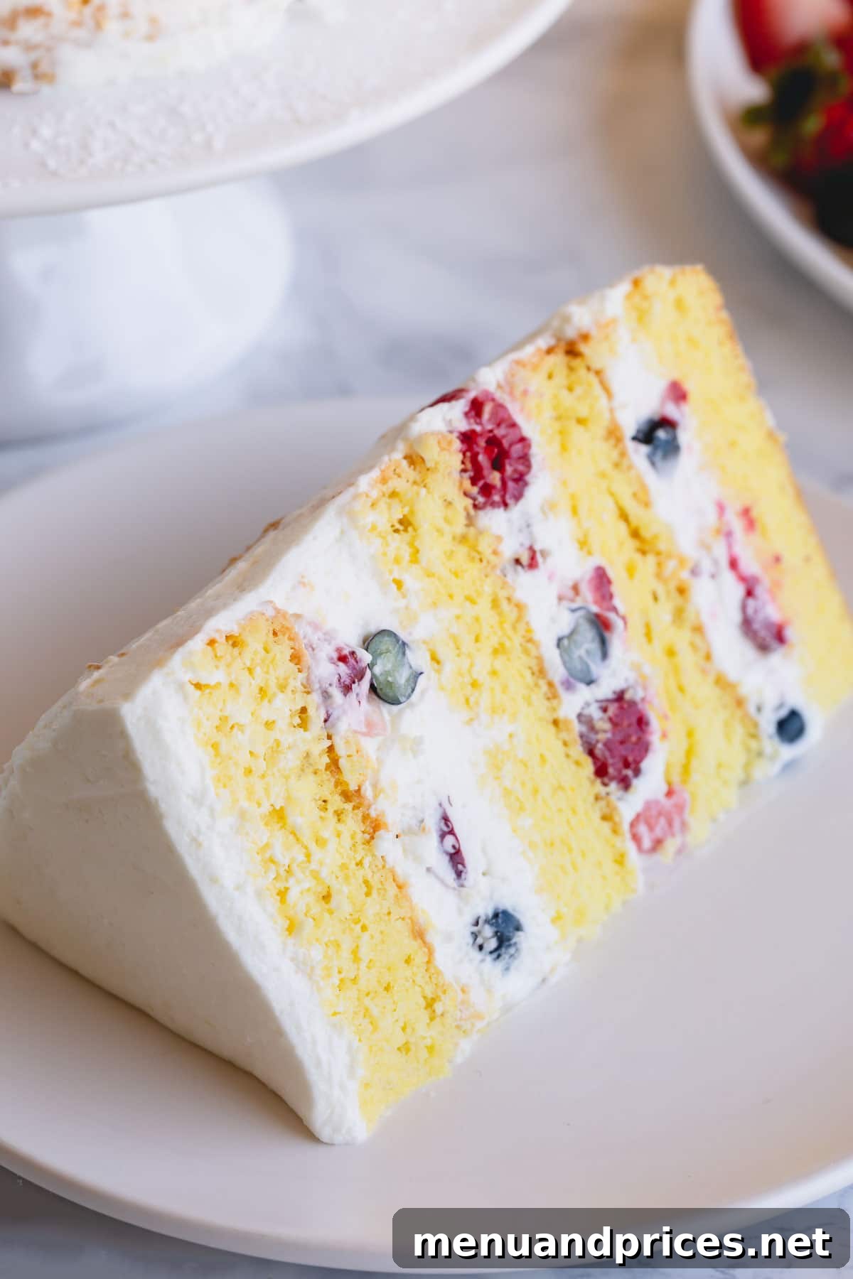 Fresh Berry Chantilly Delight 3 A perfect slice of Berry Chantilly Cake, showing four distinct layers of cake, cream, and berries, served on a white plate.