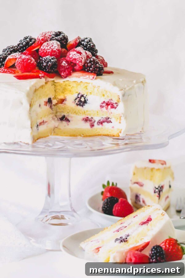 Fresh Berry Chantilly Delight 10 A whole Berry Chantilly cake on a platter, with a single slice elegantly presented on a separate plate.