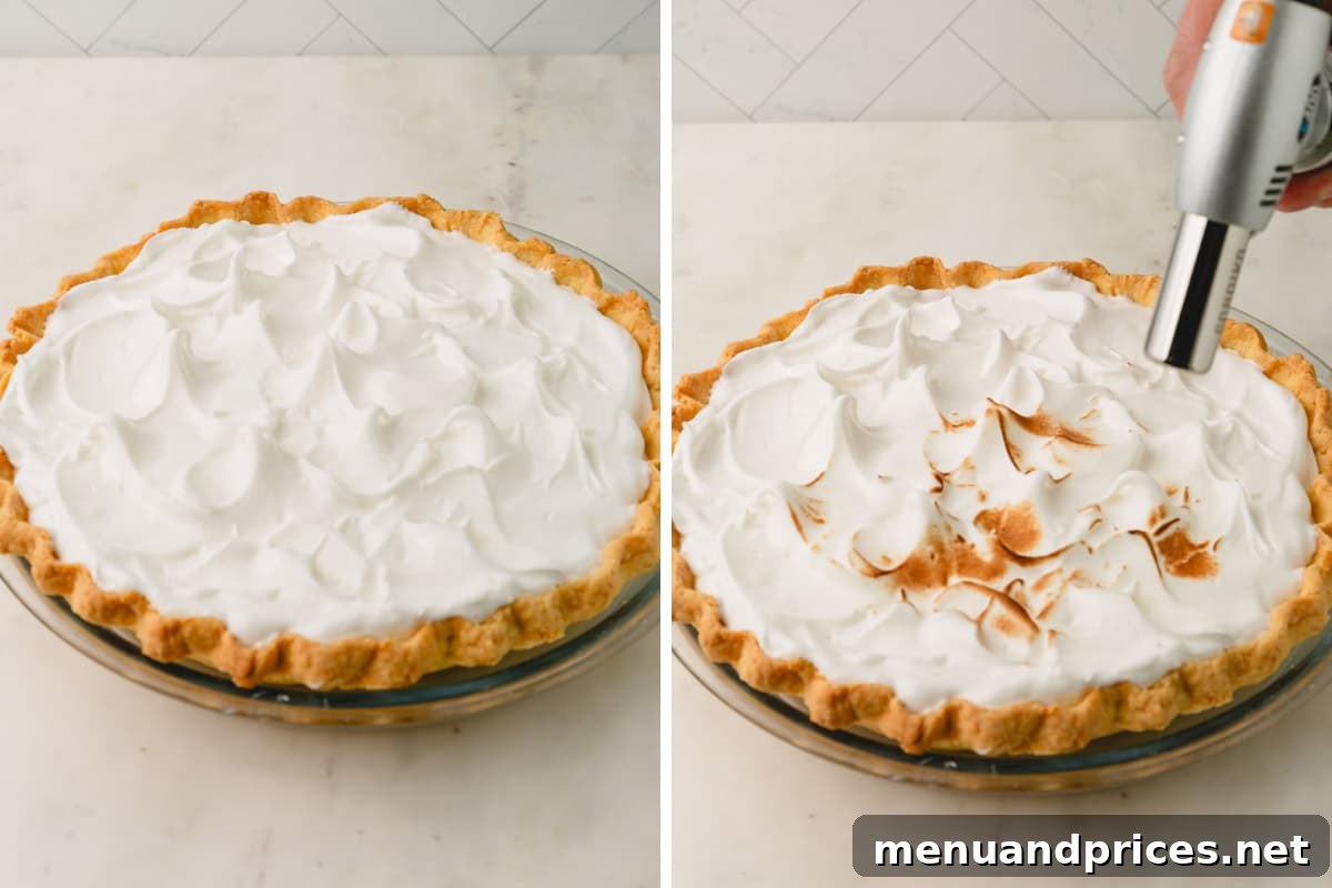 Zesty Orange Cloud Pie 11 The process of toasting meringue topping on a pie using a handheld kitchen torch to achieve a golden finish.