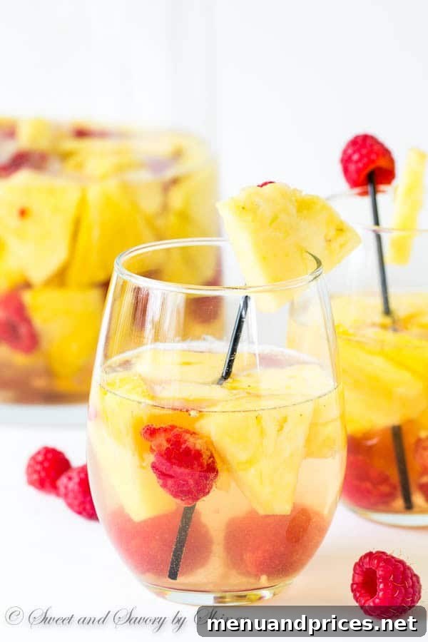 Vibrant Pineapple Raspberry Sangria in a pitcher with fresh fruit