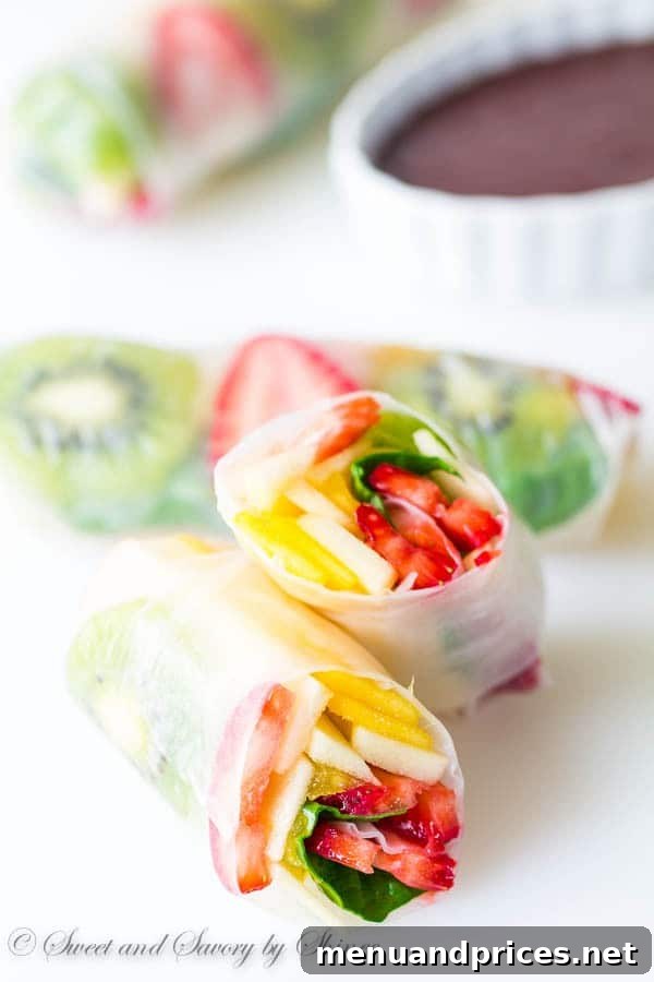 Close-up of freshly prepared Rainbow Fruit Spring Rolls arranged neatly, showcasing the colorful fruit filling through translucent rice paper. Perfect for a healthy summer treat.