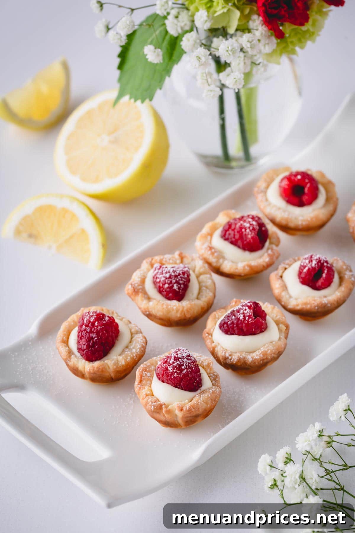 Sun-Kissed Raspberry Lemon Bites 8 A rectangular platter laden with beautifully arranged raspberry lemon tartlets, ready for serving.