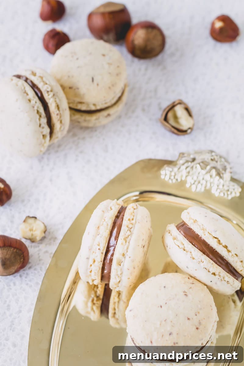 Chocolate Hazelnut Praline Macarons 3 Close-up of baked chocolate hazelnut macaron shells, showing perfectly formed feet and smooth tops.