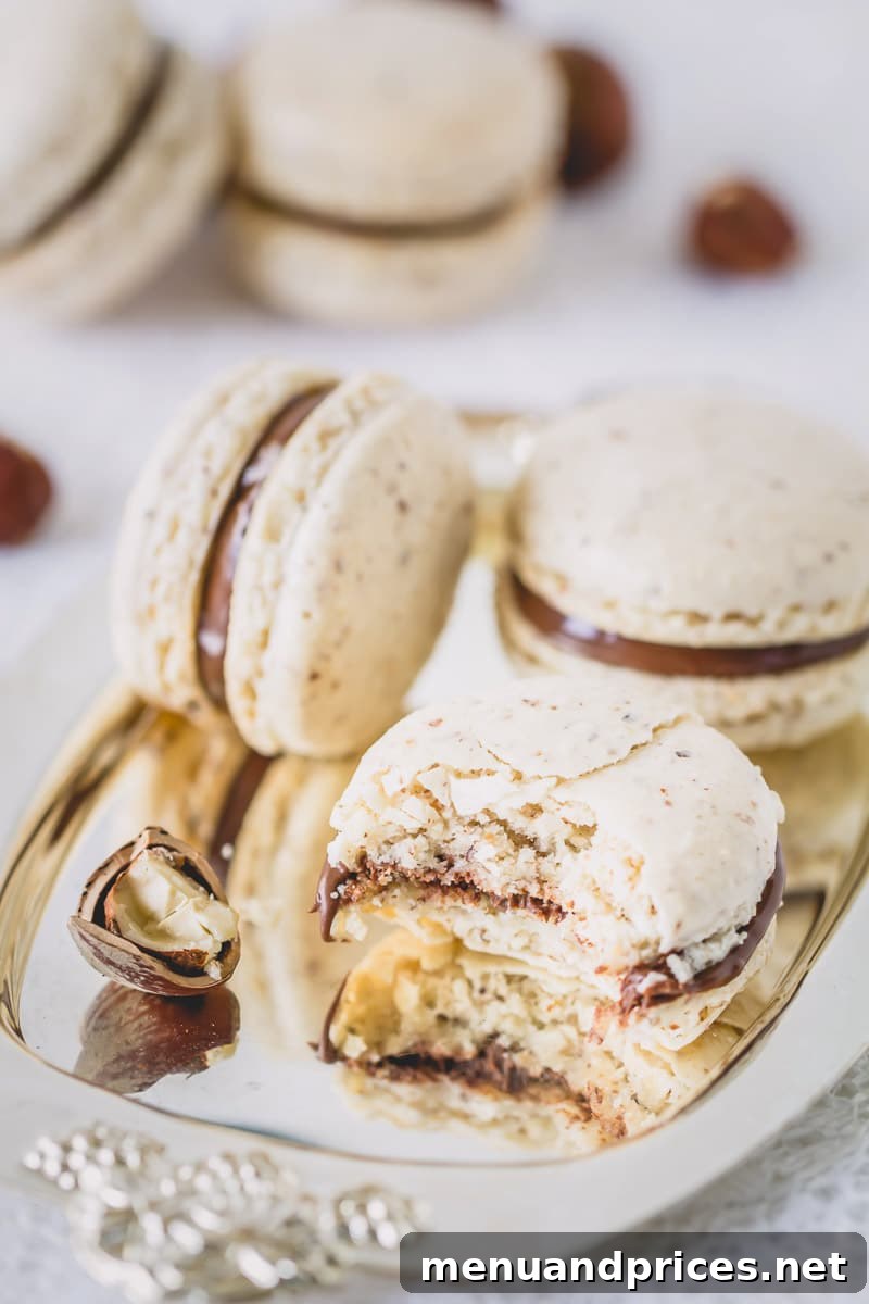 Chocolate Hazelnut Praline Macarons 5 A stack of perfectly filled chocolate hazelnut macarons with visible Nutella filling.