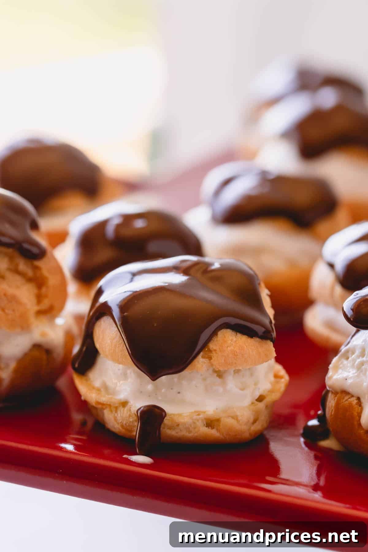 Decadent chocolate-topped profiteroles on a serving dish, ready to impress.