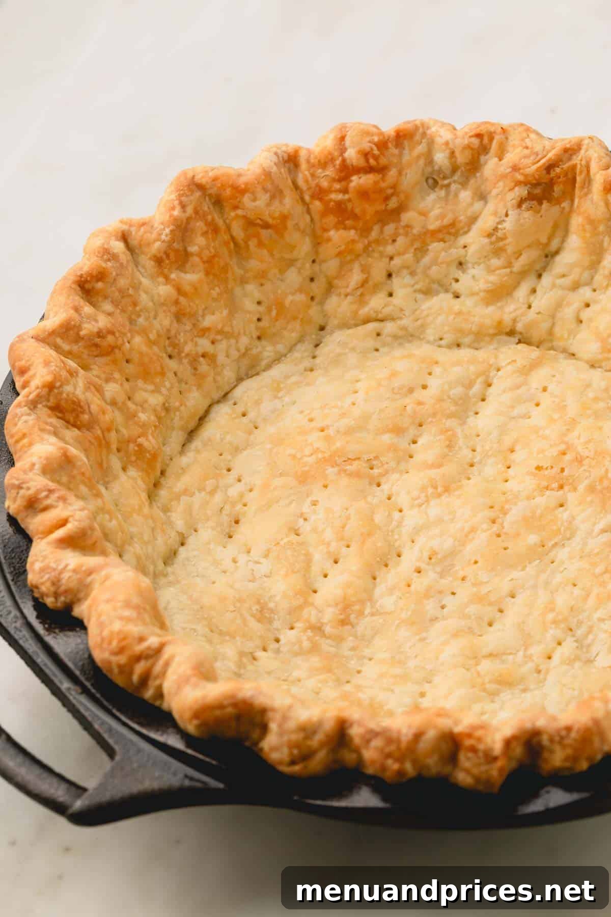 Pure Butter Flaky Pie Pastry 2 A perfectly blind-baked golden-brown pie crust resting in a classic pie dish, ready for filling.
