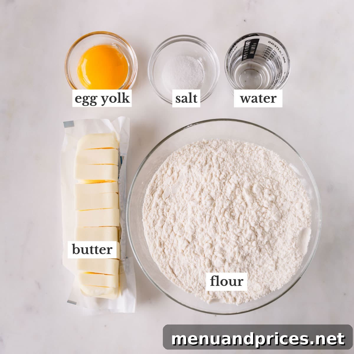 Pure Butter Flaky Pie Pastry 6 Individual bowls holding the essential ingredients for butter pie crust: flour, salt, cubed frozen butter, egg yolk, and ice water.