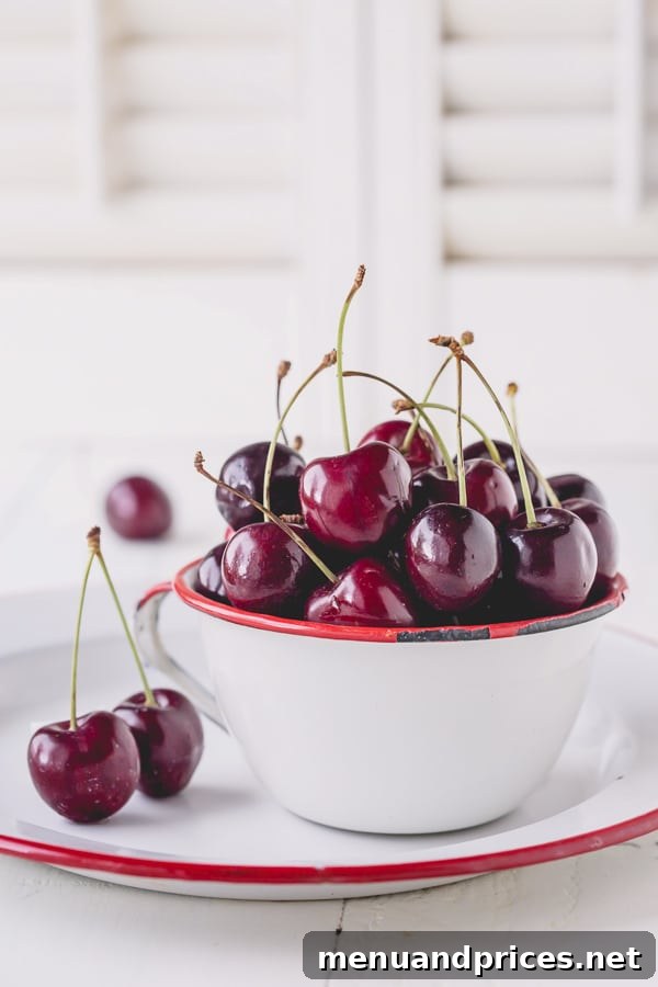 A bowl of fresh, plump sweet cherries, perfectly pitted and ready for baking, highlighting the ease of preparing fruit for pie.