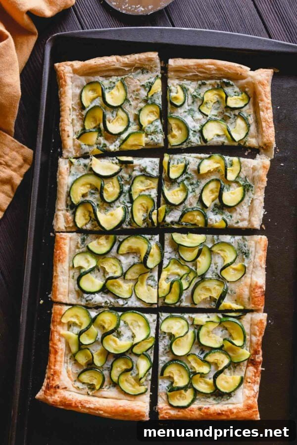 Summer Zucchini Ricotta Tart 3 Overhead shot of two freshly baked zucchini ricotta tarts on a baking sheet, ready to be sliced.