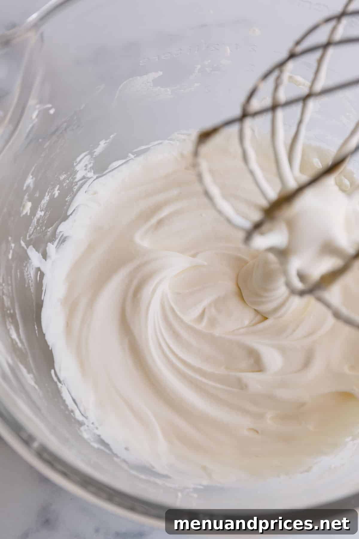 Cloud-Like Homemade Whipped Cream 5 A beautifully textured close-up of the homemade yogurt whipped cream in a mixing bowl, showcasing its light and airy consistency.